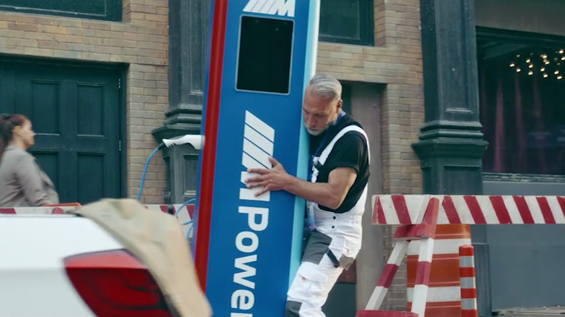 M Power electric charging station with elderly man charging BMW