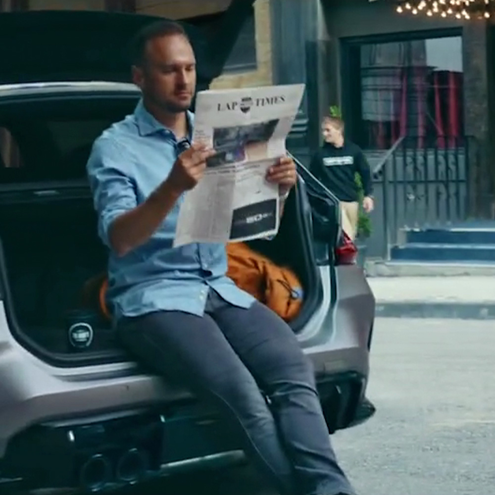 BMW M CEO Marcus Flasch cameo reading Lap Times newspaper